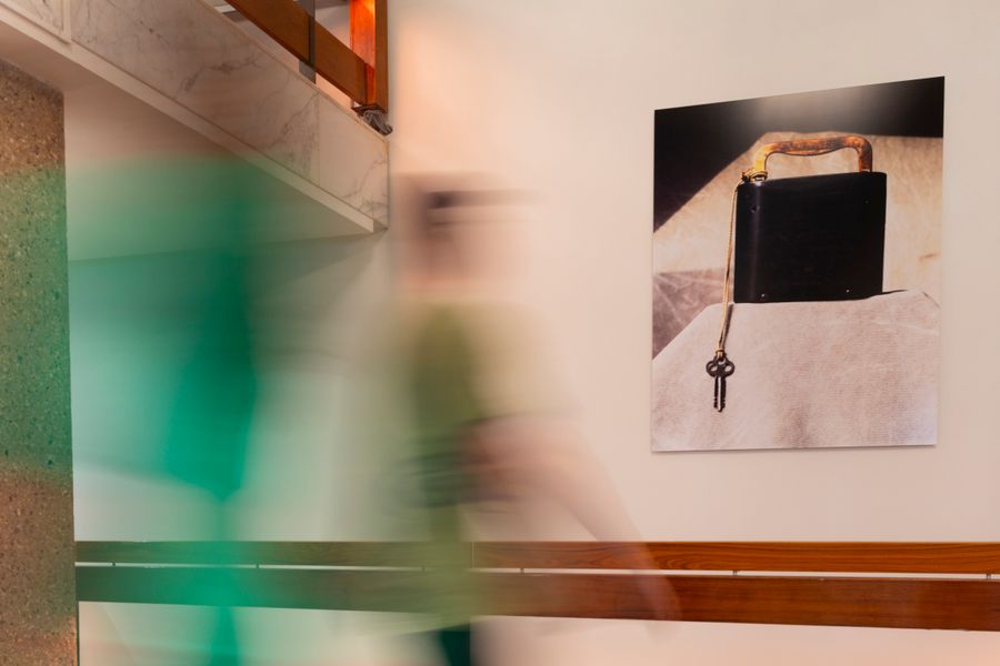 Kunstwerk met zwarte doos en sleutel aan de muur in de Doelen, met een bezoeker die voorbijloopt tijdens de Art Walks-rondgang.