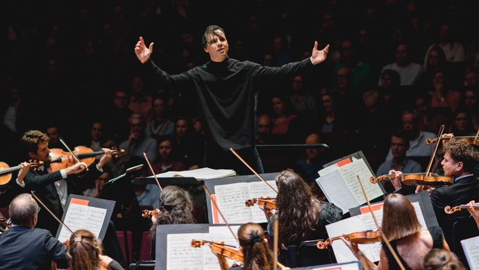 Teodor Currentzis dirigeert het orkest terwijl het publiek toekijkt
