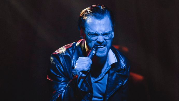Sean Nicholas Savage singing and bathed in blue light