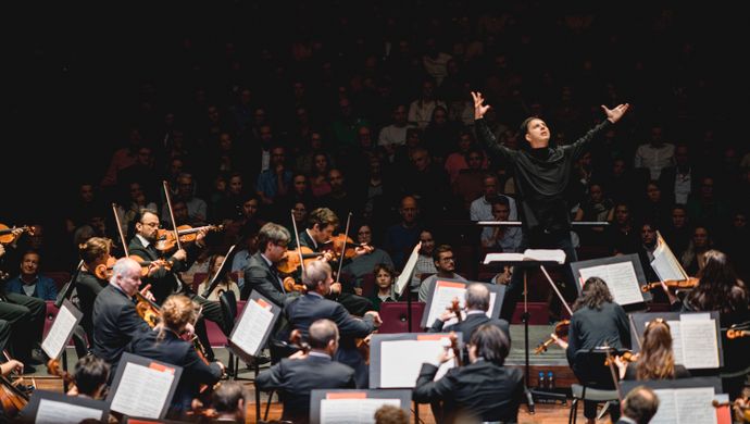 Teodor Currentzis dirigeert het orkest terwijl het publiek toekijkt
