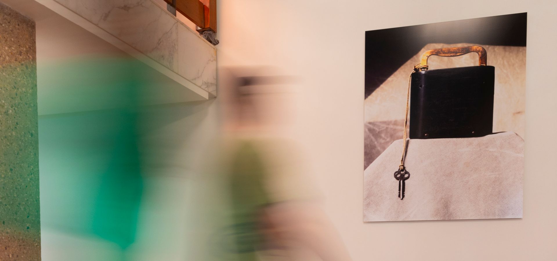 Artwork with black box and key on the wall in de Doelen, with a visitor walking past during the Art Walks tour.