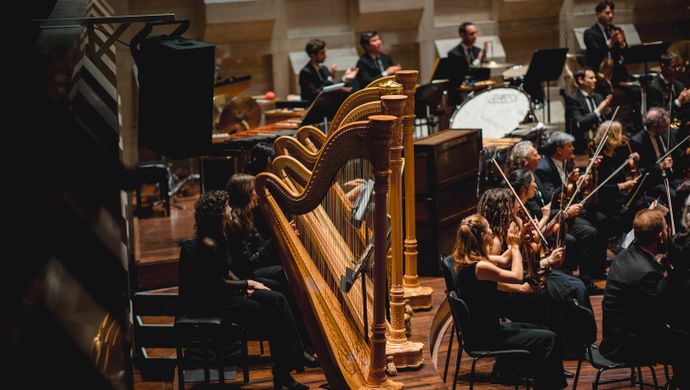Orkestleden spelen en kijken naar elkaar