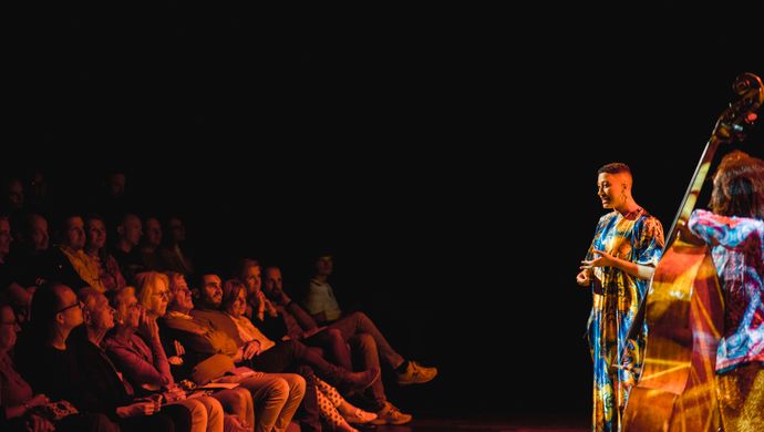Publiek kijkt naar de artiesten op het podium