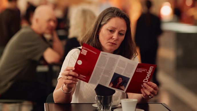 Vrouw met bruin haar leest een tijdschrift