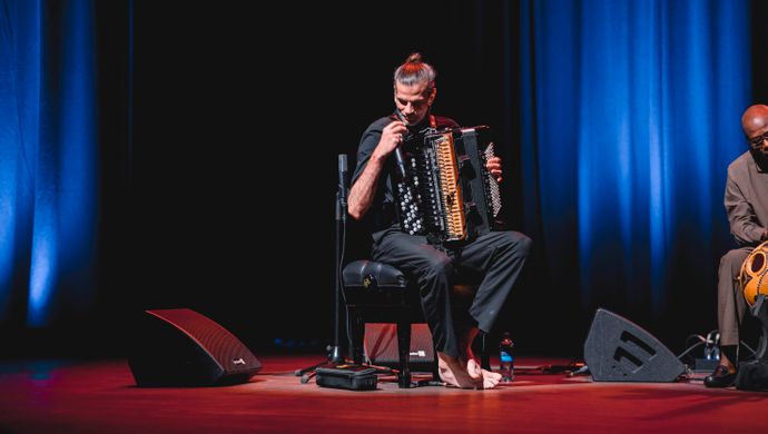 Accordeonist kijkt naar de rode vloer