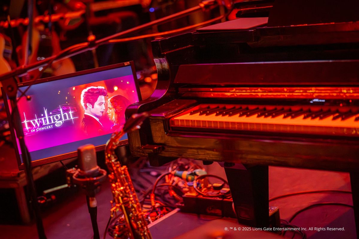 Foto van het concert met het scherm, orkest en kaarsen op de achtergrond