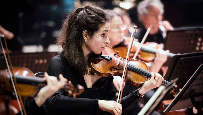 Vrouw in orkest die een viool speelt