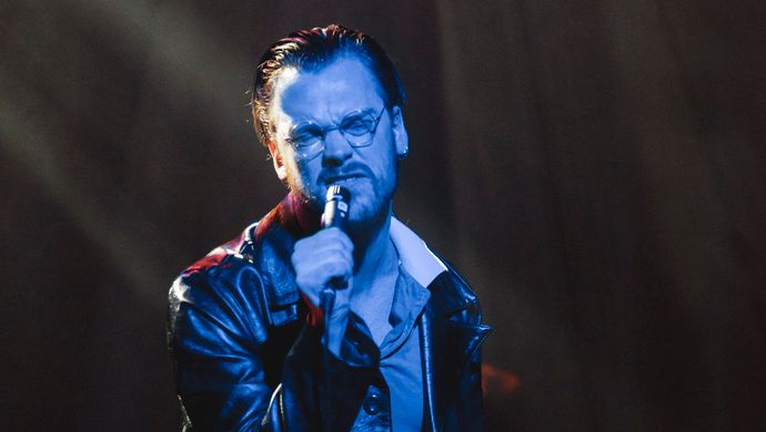 Sean Nicholas Savage singing and bathed in blue light
