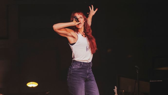 Wende sings with her arms raised toward the audience