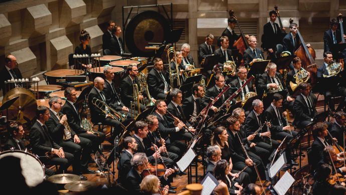 Orkestleden spelen en kijken naar de dirigent