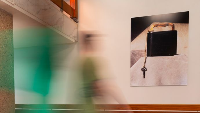Artwork with black box and key on the wall in de Doelen, with a visitor walking past during the Art Walks tour.