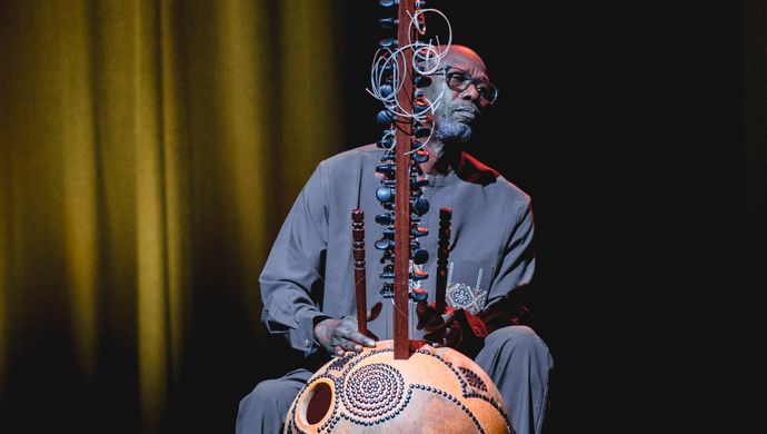 Muzikant speelt aandachtig de kora